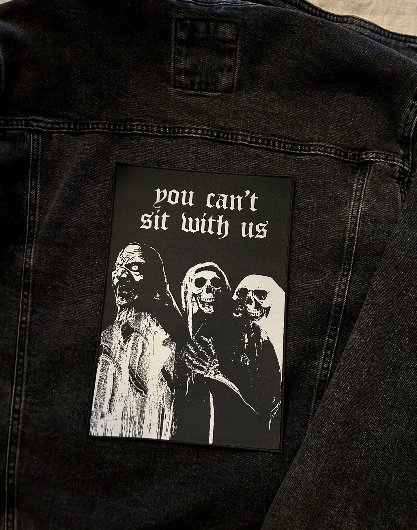 large printed back patch with design of ghouls and slogan you can't sit with us