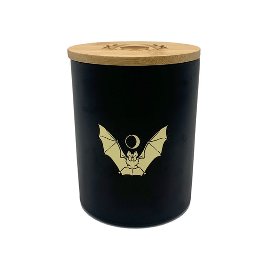 soy wax candle with matte black base and gold foil design of bat and crescent moon. T'erre de hermes scent.