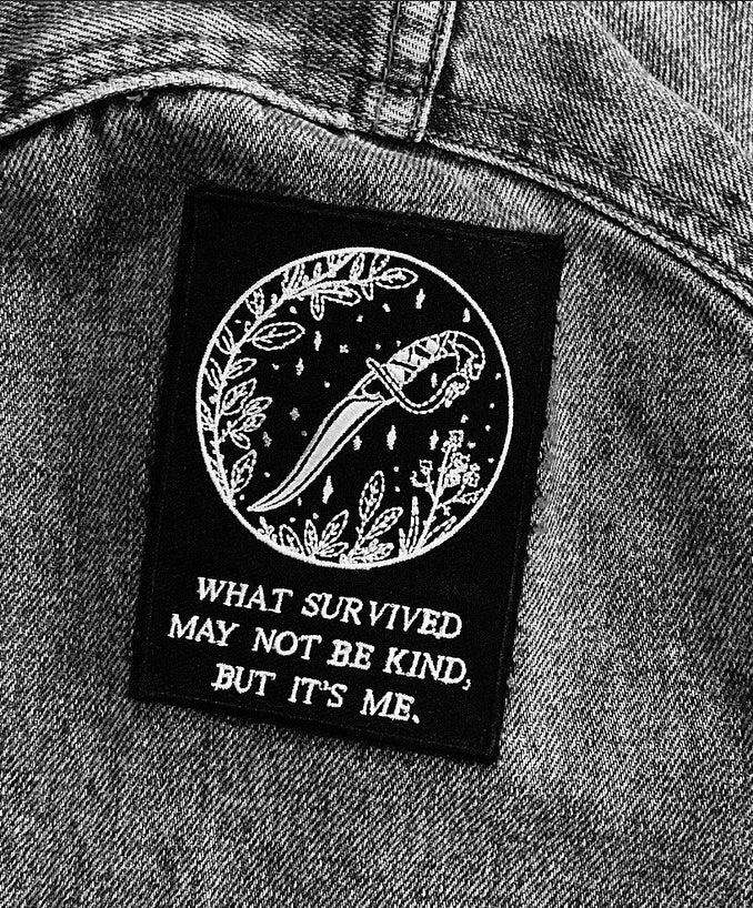 black and white embroidered iron-on patch with dagger and foliage designed by Amrit Brar and 13th Press. Iron-on backing and machine embroidered design.