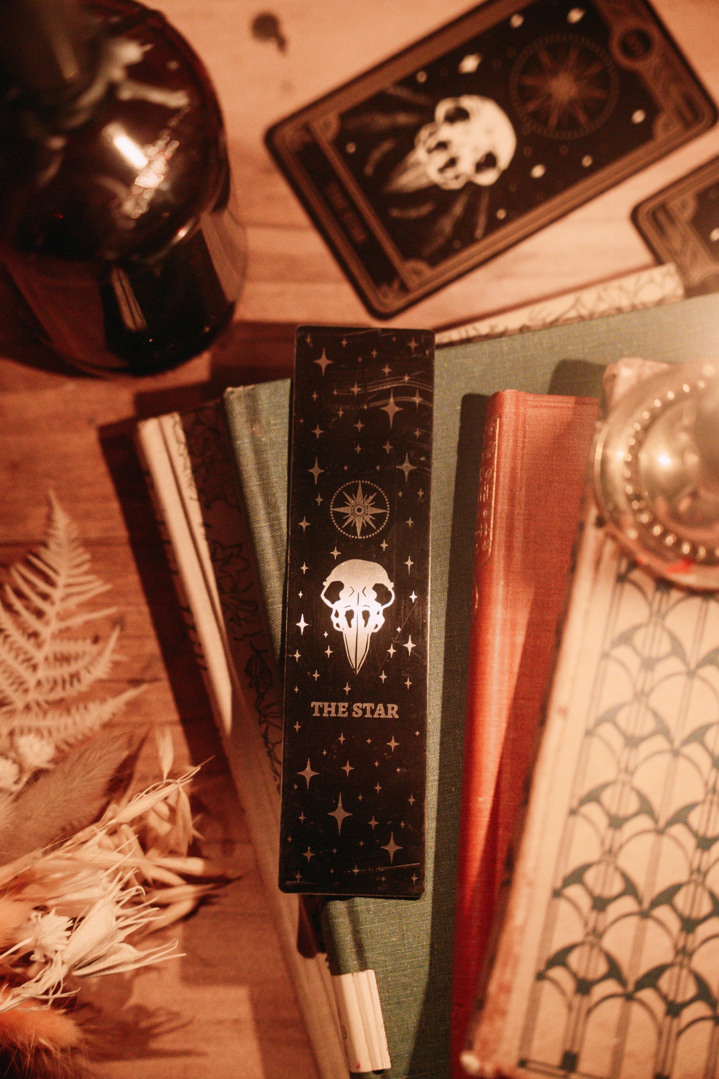 bookmark with the Star tarot card design. Art from the Marigold tarot deck by Amrit Brar and 13th Press. Black and silver metal bookmark.