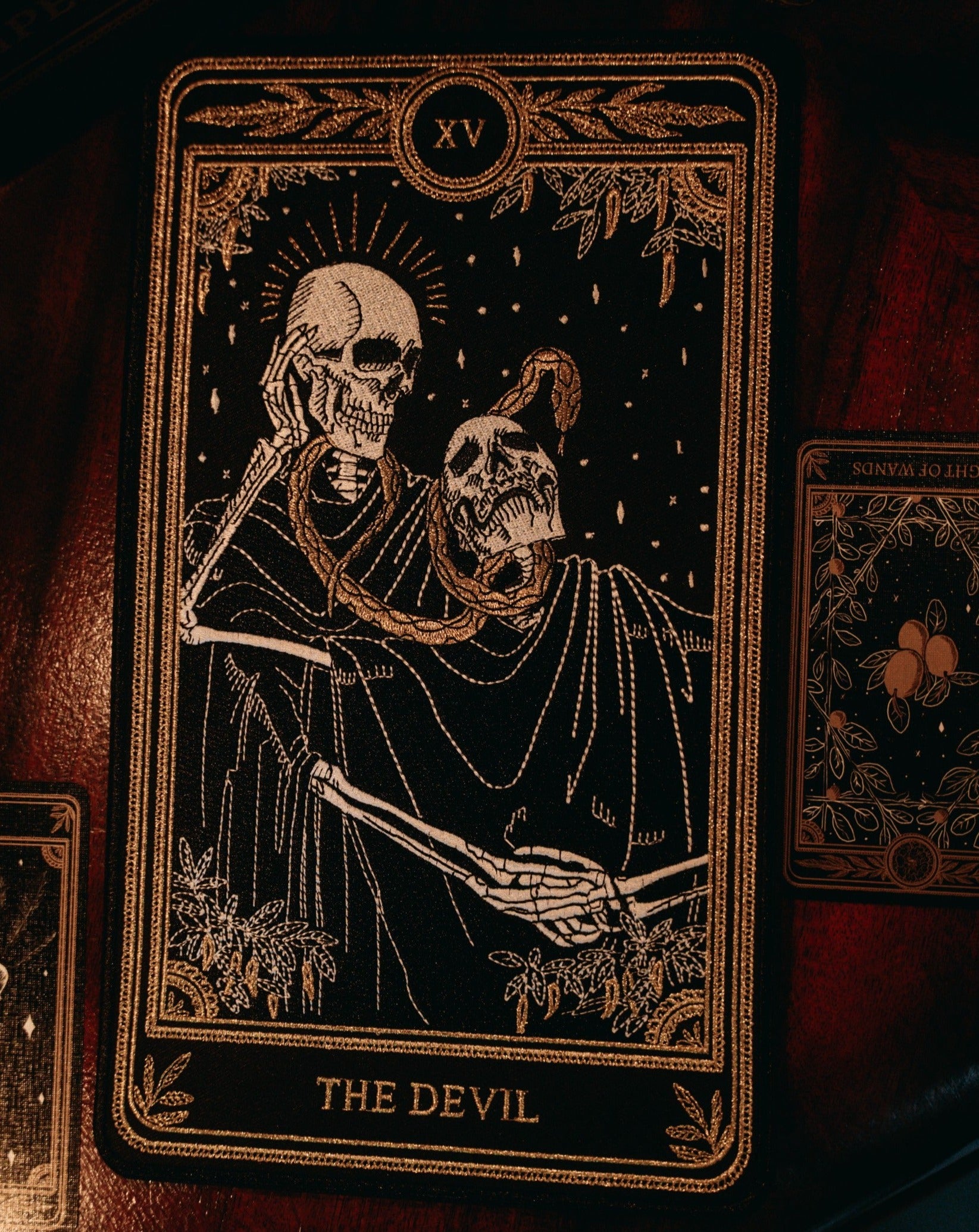 the devil tarot embroidered patch with black, gold, and white thread design from the Marigold Tarot deck by Amrit Brar and 13th Press