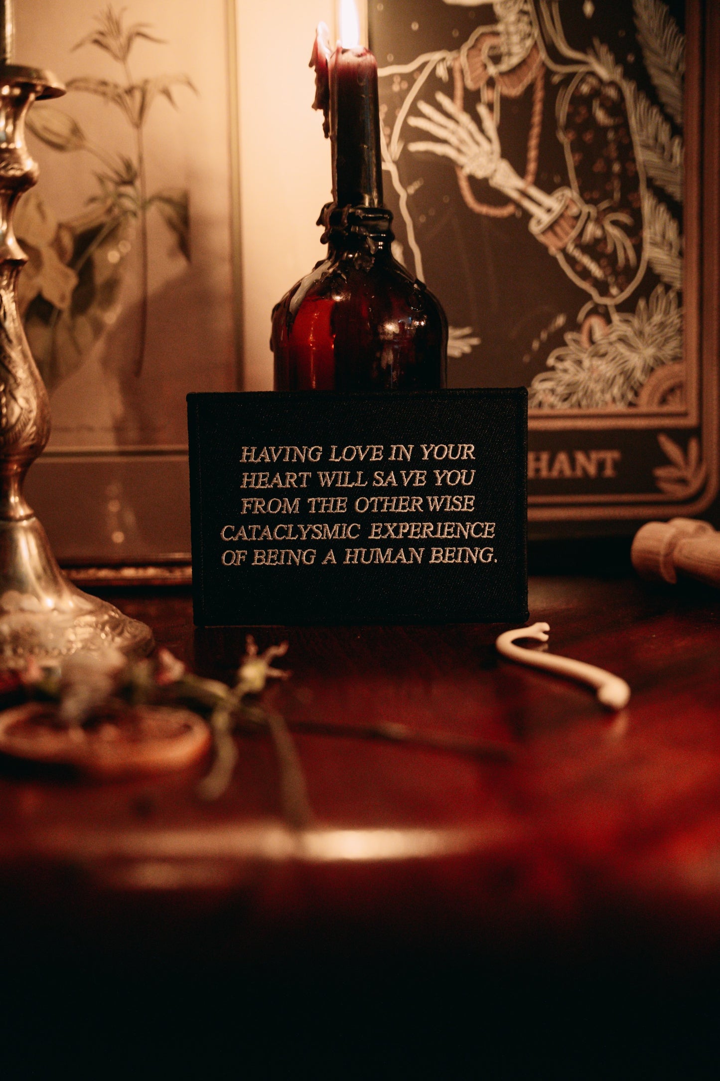 black and white embroidered iron-on patch designed by Amrit Brar and 13th Press. Text reads "having love in your heart will save you from the otherwise cataclysmic experience of being a human being"