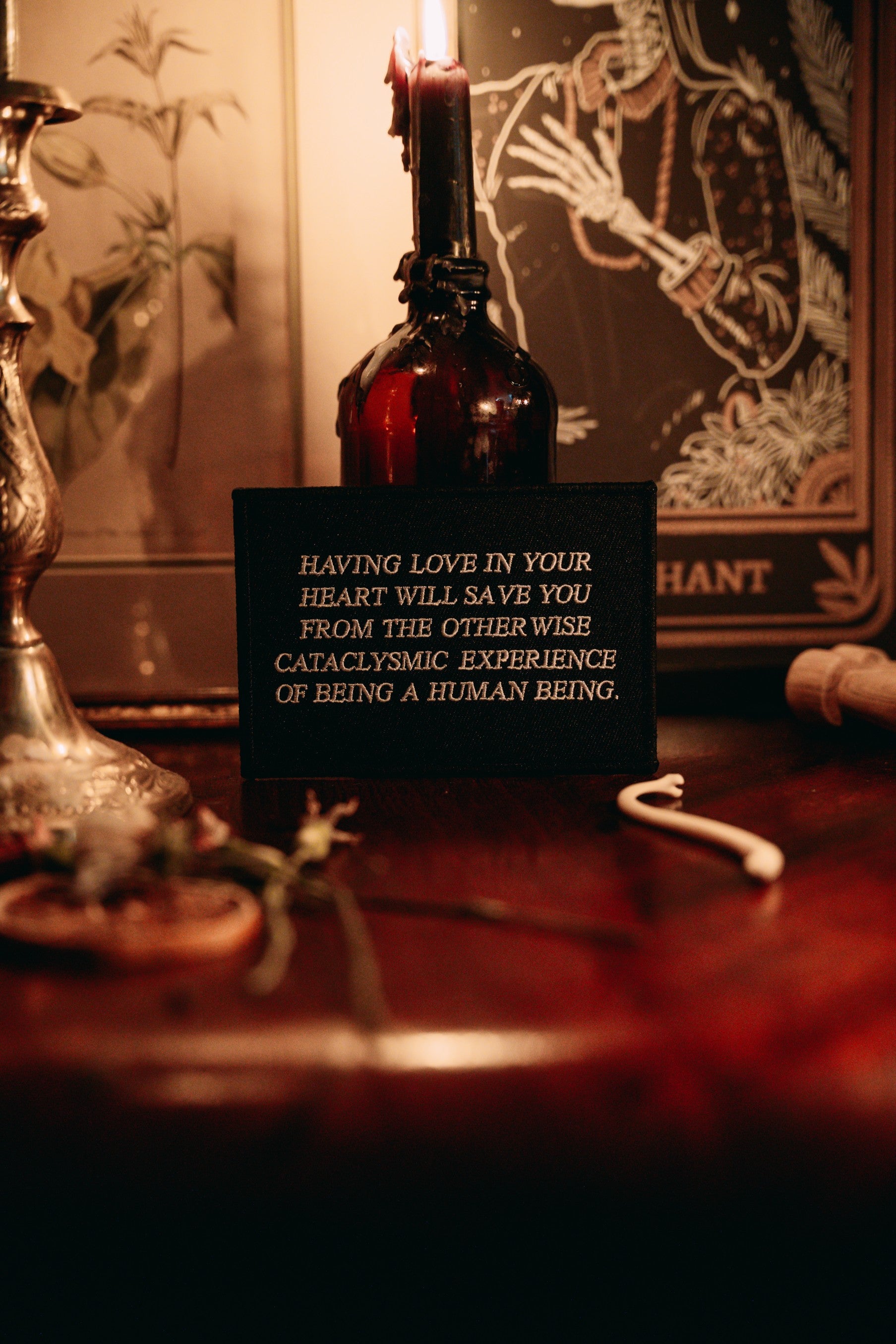 black and white embroidered iron-on patch designed by Amrit Brar and 13th Press. Text reads "having love in your heart will save you from the otherwise cataclysmic experience of being a human being"