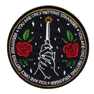 machine embroidered iron-on patch with knife and roses, text reads "you are only getting stranger".