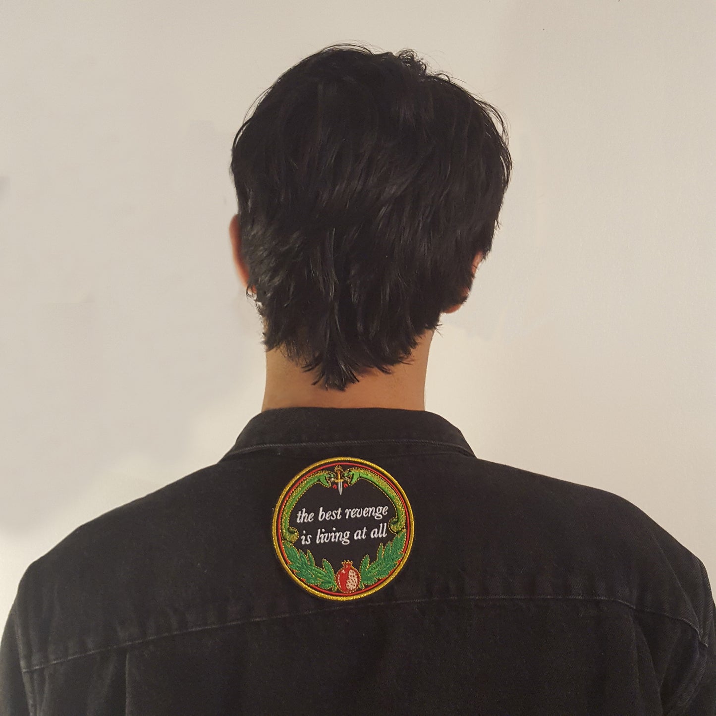 machine embroidered iron-on patch designed by Amrit Brar and 13th Press reads "the best revenge is living at all" with two serpents and pomegranate with leaves