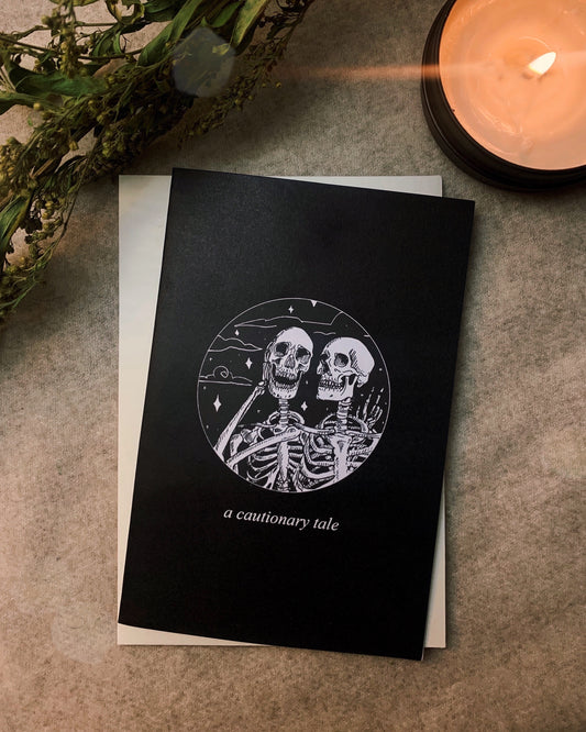 Greeting card, front reads "A Cautionary Tale", size 4"x6", Black and white printing, Blank, white inside, 250gsm paper, 100gsm cream envelope. Artwork by Amrit Brar, produced by 13th Press. Stationery, cards, tarot art
