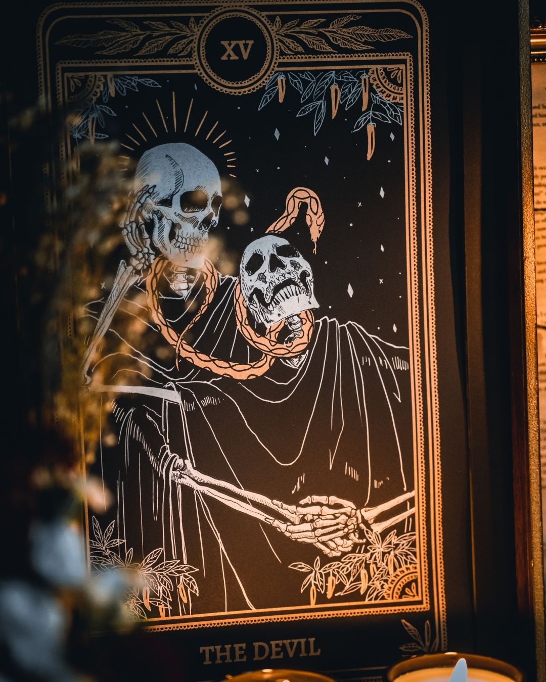 Tarot Devil print from the Marigold Tarot deck by Amrit Brar and 13th Press. With skull and candle decor on altar. Skeleton and serpent. Gold ink