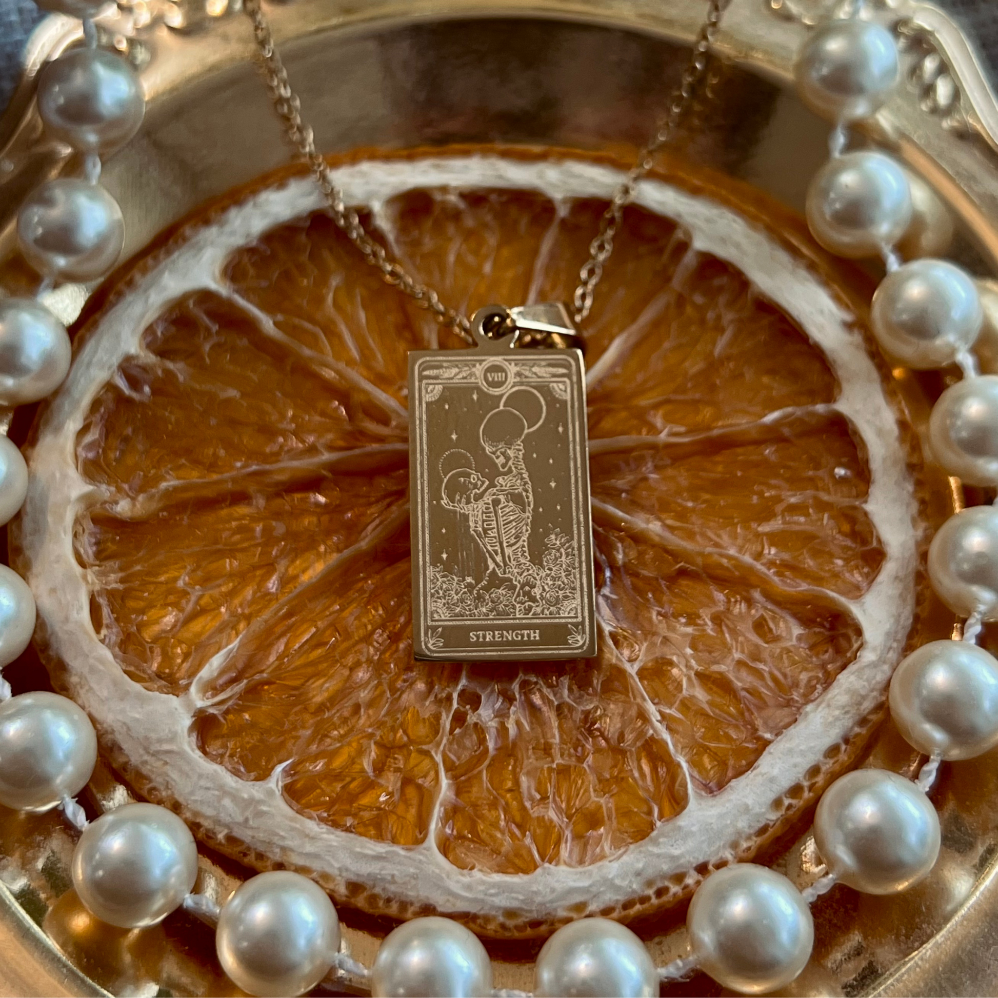 Necklace with a pendant on a dried orange slice surrounded by pearls