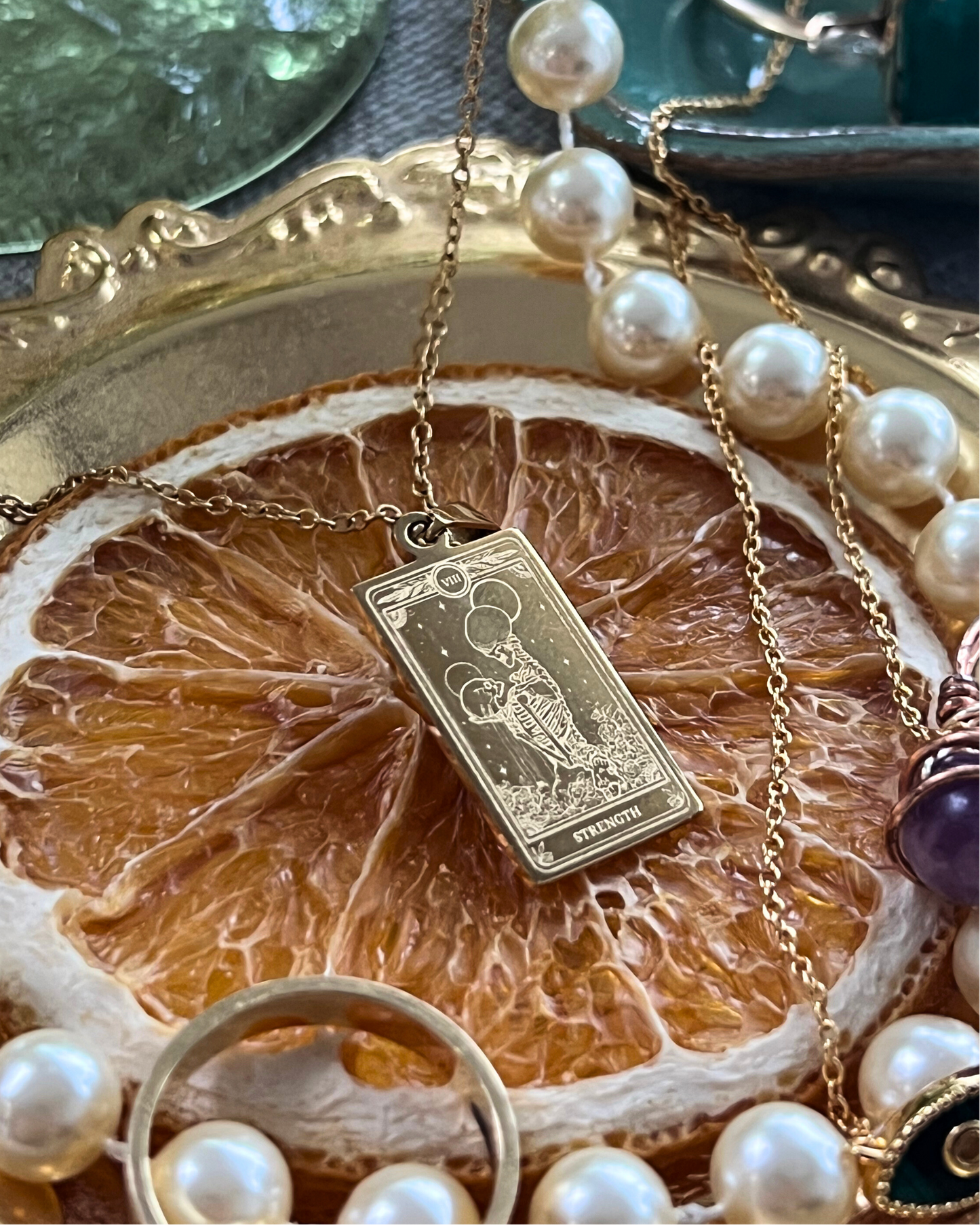 Necklace with a gold pendant on a dried orange slice