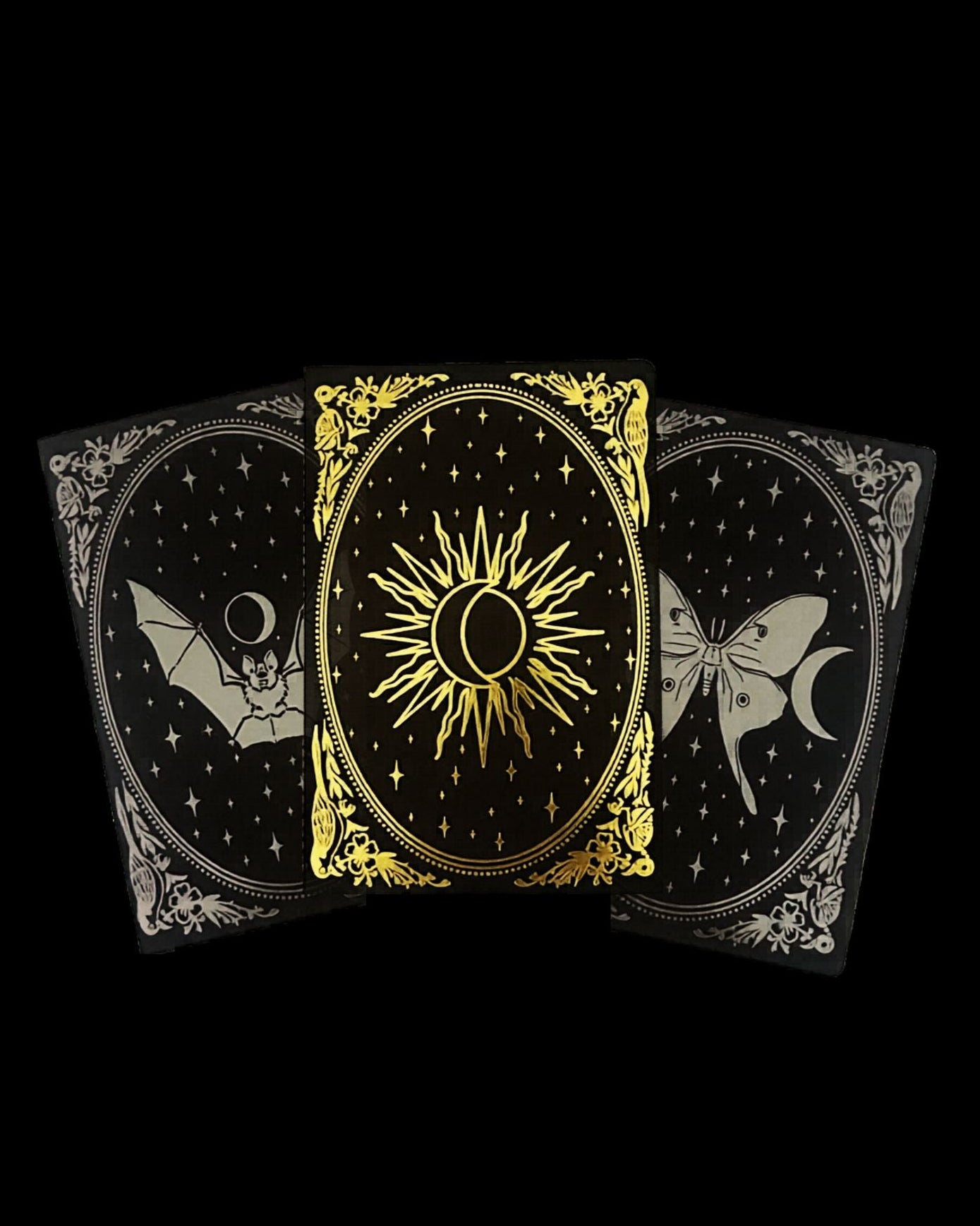 Three black notebooks with gold and gunmetal foil designs of a sun, moon, and luna moth on a black background.