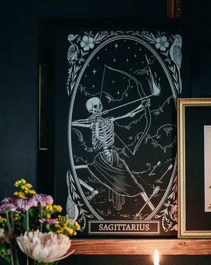 Sagittarius zodiac sign art print on shelf with dried flowers and candle light