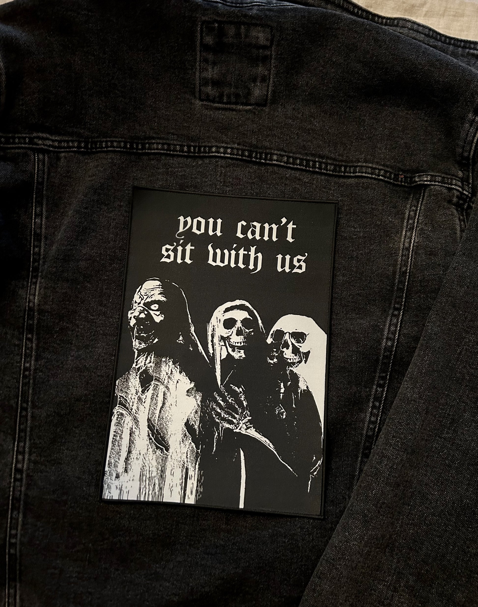 large printed back patch with design of ghouls and slogan you can't sit with us