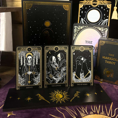 Collection of tarot cards with intricate designs on a purple cloth with black wood tarot card stand for readings.