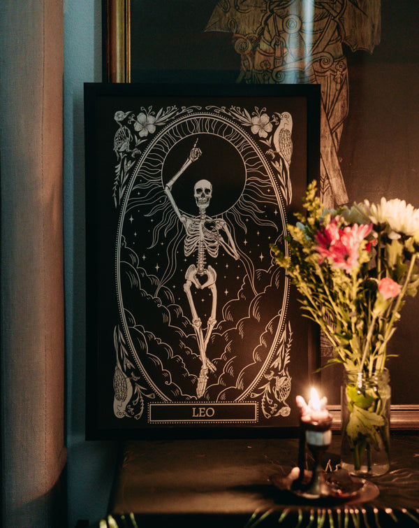 leo zodiac print design from the mirror oracle deck on altar space with candle light and dried flowers