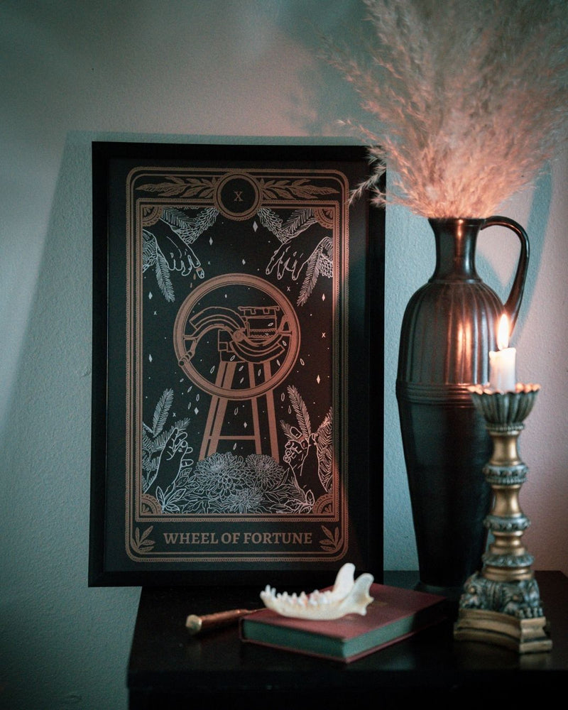 tarot card art print of the Wheel of Fortune card from the Marigold Tarot deck by Amrit Brar and 13th Press. With lit candle, vase and foliage.