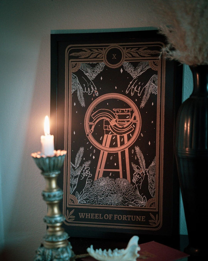 tarot card art print of the Wheel of Fortune card from the Marigold Tarot deck by Amrit Brar and 13th Press. With lit candle and foliage.