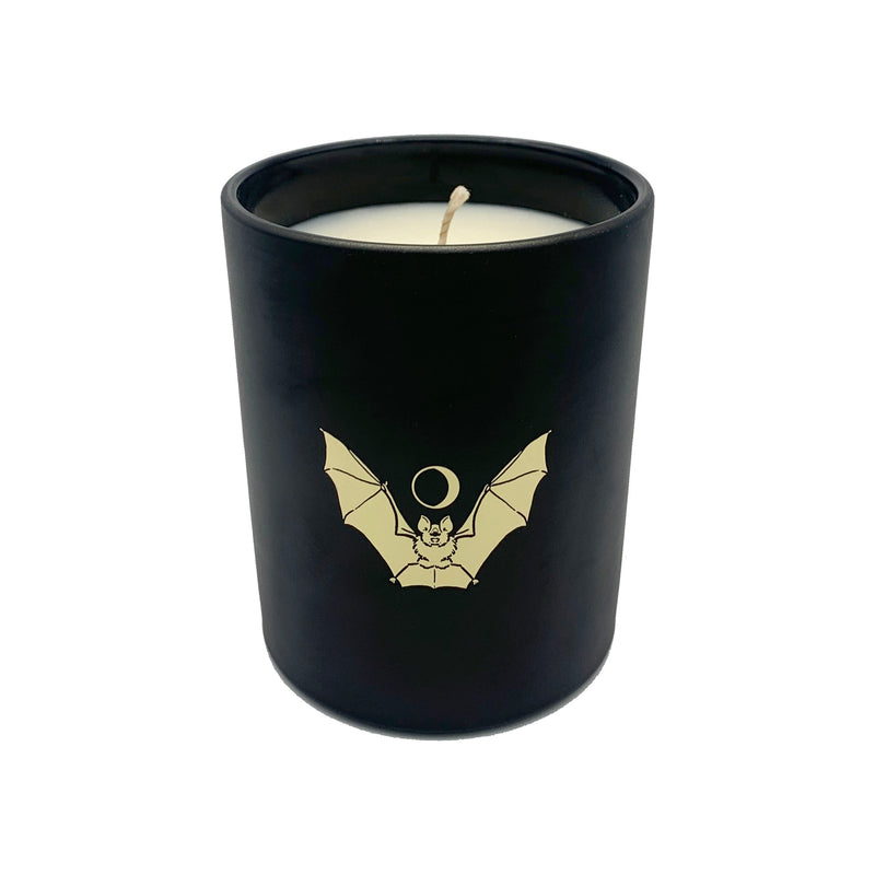 soy wax candle with matte black base and gold foil design of bat and crescent moon. T'erre de hermes scent. 
