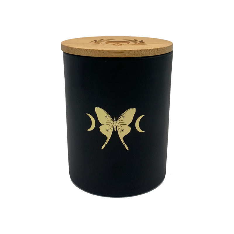 soy wax candle with matte black base and gold foil design of luna moth and crescent moons. Vetiver, cedar, and citrus.