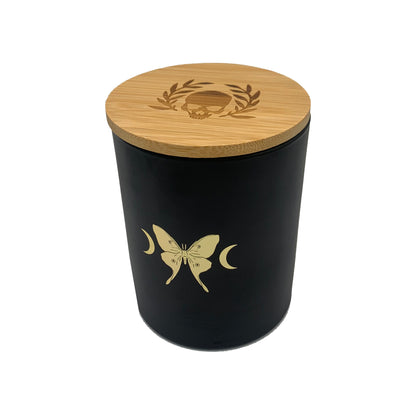 soy wax candle with matte black base and gold foil design of luna moth and crescent moons. Vetiver, cedar, and citrus.