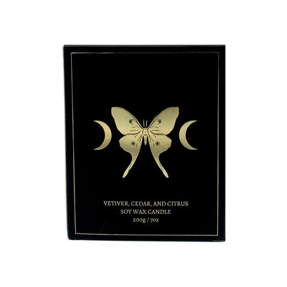 soy wax candle with matte black base and gold foil design of luna moth and crescent moons. Vetiver, cedar, and citrus.