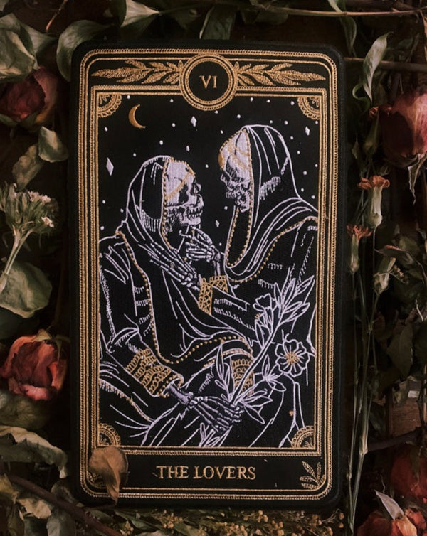 machine embroidered large iron-on back patch of the Lovers tarot card design from the Marigold Tarot deck by Amrit brar and 13th Press. Two skeleton figures embracing on a bed of roses.
