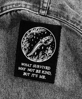 black and white embroidered iron-on patch with dagger and foliage designed by Amrit Brar and 13th Press. Iron-on backing and machine embroidered design.