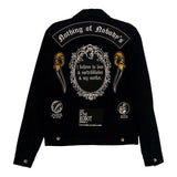 black and white iron-on embroidered back patch design from the Marigold Tarot deck by Amrit Brar and 13th Press. Text reads "i believe in love, switchblades, and my mother". Patches on black denim jacket.