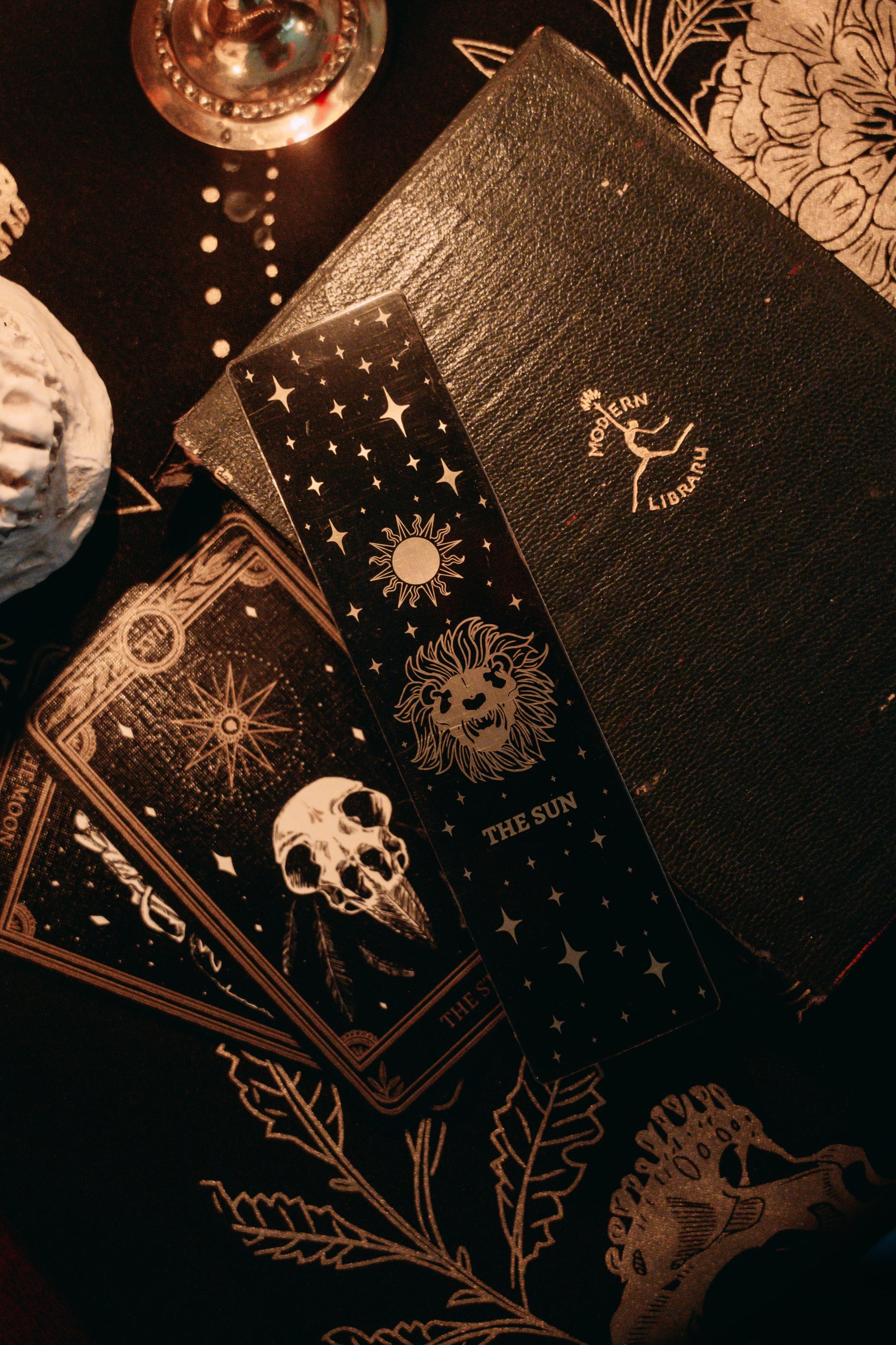 bookmark with the Sun tarot card design. Art from the Marigold tarot deck by Amrit Brar and 13th Press. Black and gold metal bookmark.