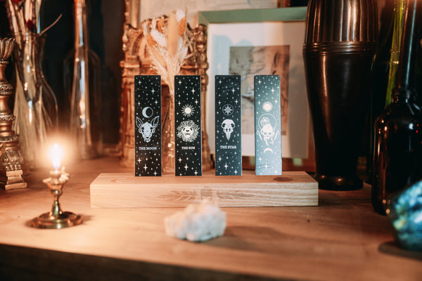 Bookmark bundle with the Star, Sun, Moon, Marigold Night designs from Marigold Tarot deck by Amrit Brar and 13th Press. Black, gold, and silver metal.