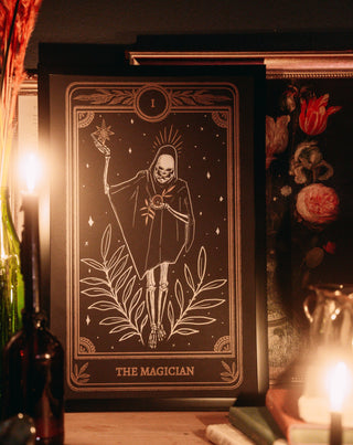 tarot art print in frame on wall of the Magician card from the Marigold Tarot deck by Amrit Brar and 13th Press on altar with candle light and tarot card reading