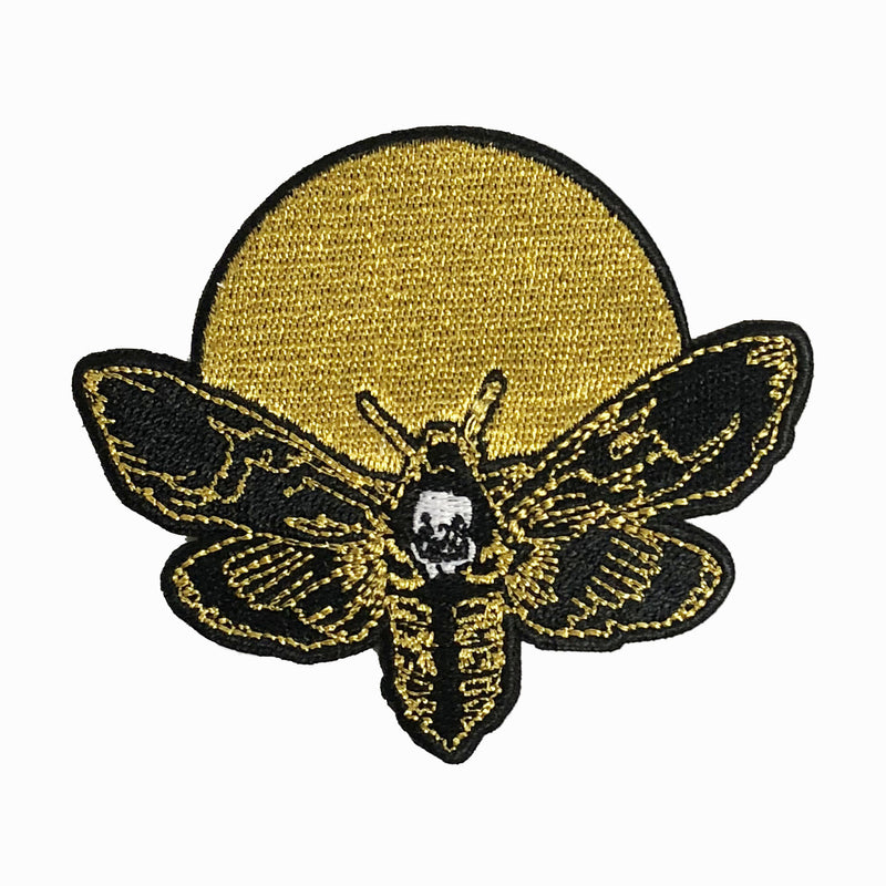 embroidered iron-on patch of moth and moon design by Amrit Brar and 13th Press. Machine embroidered with black, white, and gold thread.
