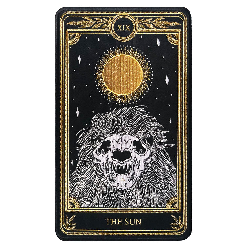 large embroidered patch of sun tarot card design from the Marigold Tarot deck by Amrit Brar and 13th Press. Skeleton of lion figure with sun and stars.