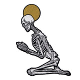 skeleton figure praying with moon in background design by Amrit Brar and 13th Press. Machine embroidered iron-on patch