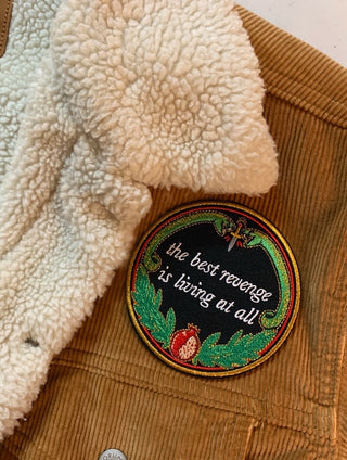 machine embroidered iron-on patch designed by Amrit Brar and 13th Press reads "the best revenge is living at all" with two serpents and pomegranate with leaves