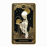 hard enamel pin of strength tarot card from the Marigold Tarot deck by Amrit Brar and 13th Press. Black pin with gold and white ink. Pin for jackets and bags